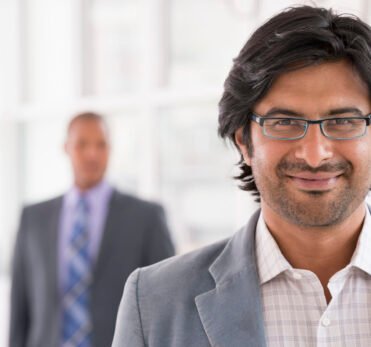 New York City June,USA,A business environment, a light airy city office. Business people. A man in a light jacket wearing glasses.