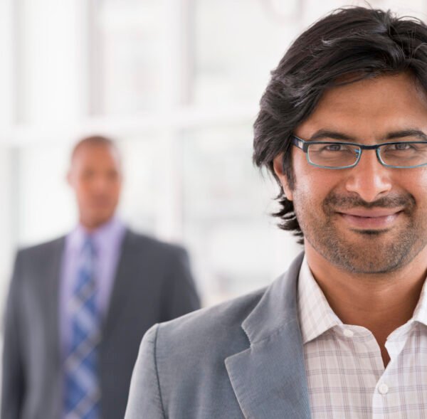 New York City June,USA,A business environment, a light airy city office. Business people. A man in a light jacket wearing glasses.