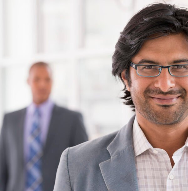 New York City June,USA,A business environment, a light airy city office. Business people. A man in a light jacket wearing glasses.