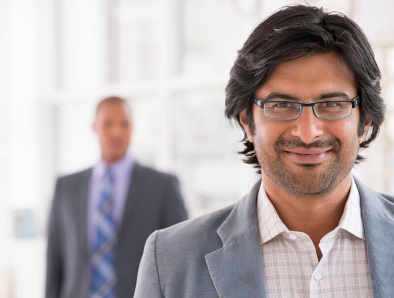 New York City June,USA,A business environment, a light airy city office. Business people. A man in a light jacket wearing glasses.