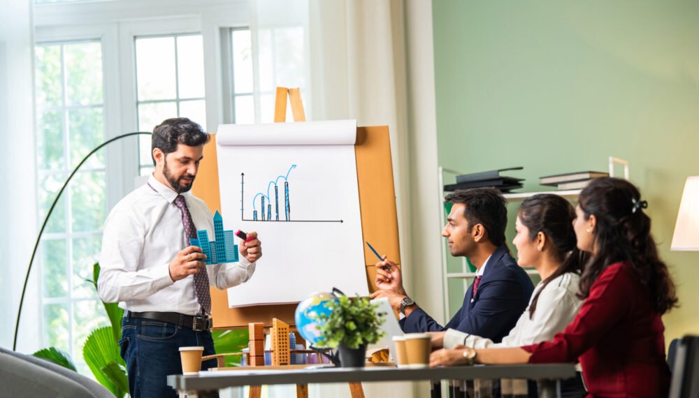 group-of-businesspeople-looking-at-young-indian-as-2024-06-03-22-32-05-utc