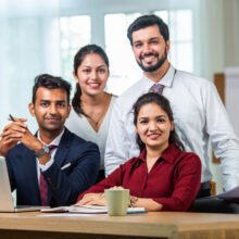 Indian asian young business professionals using laptop on desk discussing strategy