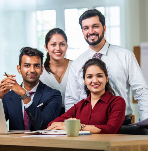 Indian asian young business professionals using laptop on desk discussing strategy