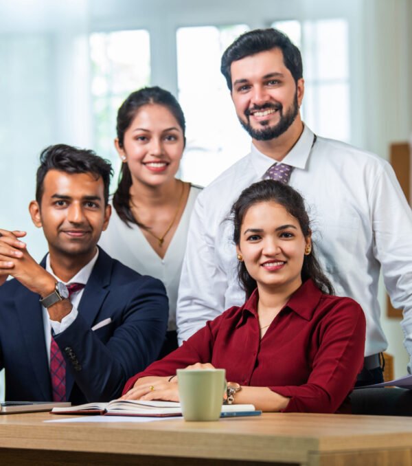 Indian asian young business professionals using laptop on desk discussing strategy