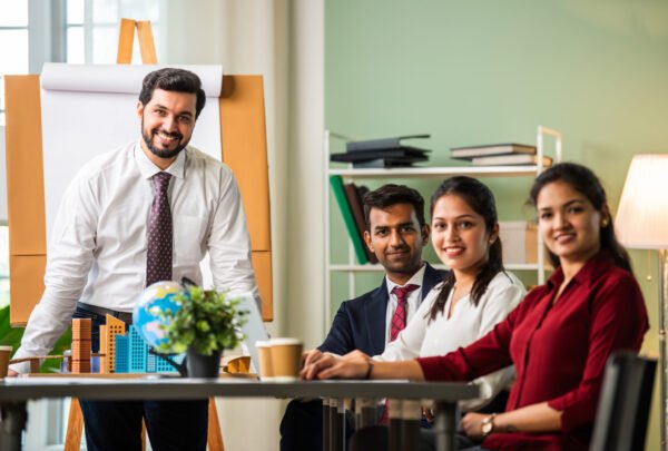 Indian asian young business professionals using laptop on desk discussing strategy